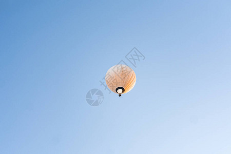 在湛蓝的天空中飞行的黄色热气球图片