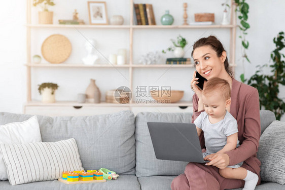 忽视婴儿使用笔记本电脑在她的拉普图片