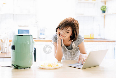 快乐的微笑美丽的亚洲女人在笔记本电脑上工作图片