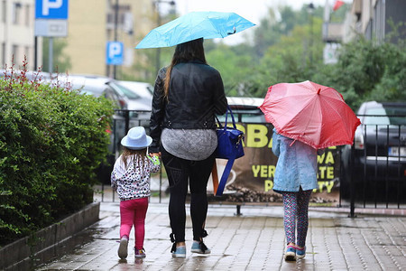 妈和孩子在街上雨中图片