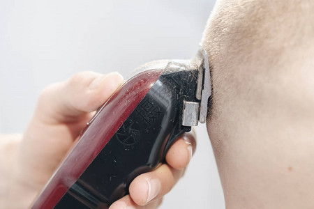 客户头部和红电动理发师的红色电插管手贴近图片
