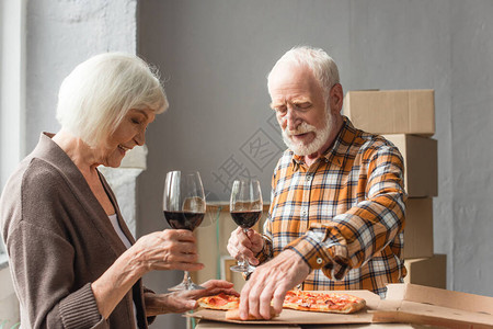 高龄夫妇拿着酒杯男人在新房子里图片