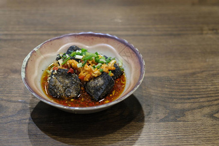 破 碗一碗臭豆腐放在旧木制桌前传统背景