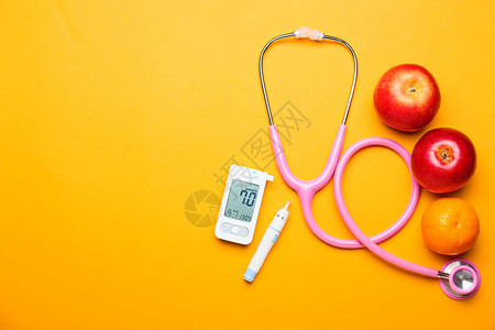 彩色背景下的数字血糖仪柳叶刀笔听诊器和水果糖尿病概念背景图片