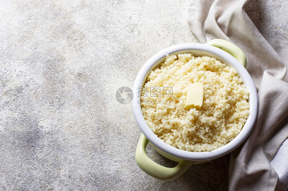 浅色背景下锅中加黄油的蒸粗麦粉图片