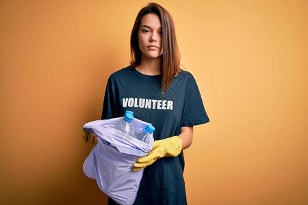 美丽的志愿者女孩关怀环境做志愿者拿着垃圾瓶的袋子图片