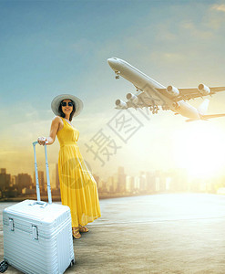 美丽的女人和旅行的李站在机场航站楼图片