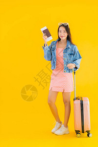 黄色背景中带护照和登机牌的行李旅行袋的美丽亚洲背景图片