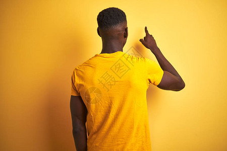 身穿临时T恤衫的非洲青年男子站在孤立的黄色背景上站立图片