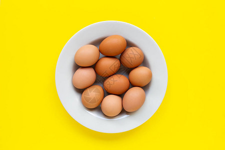 黄色背景上的鸡蛋顶视图背景图片