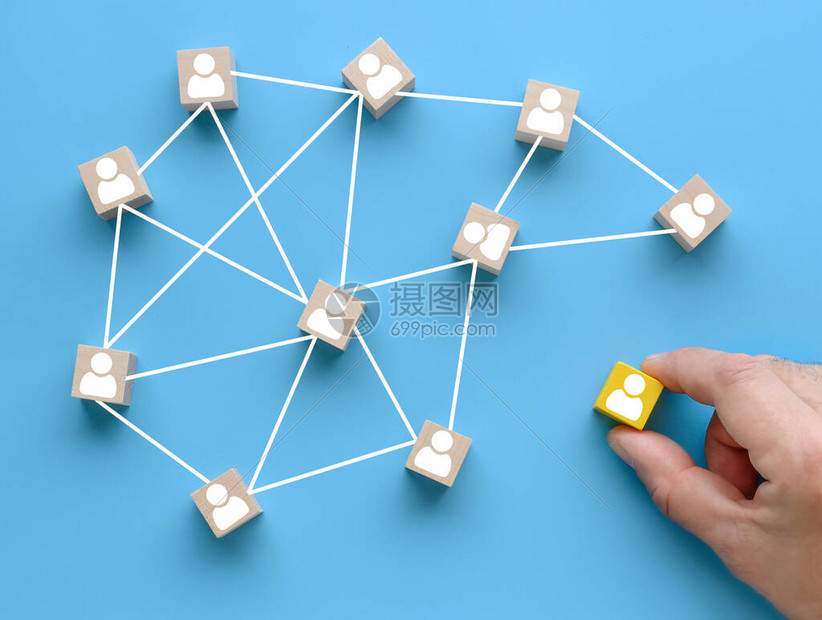 组建团队加入一个团队蓝色背景上带有人形图标的木制立方体社交网络领导力团队建设理念手将一个木块图片