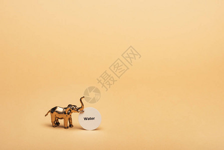 金象玩具大象在黄背景缺水概念的卡图片