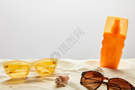 黄色和棕黄色太阳墨镜和橙色瓶子的防晒霜图片