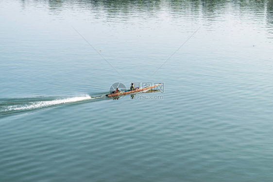 湄公河夕阳下划船捕鱼的渔夫图片