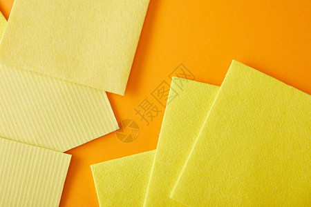 黄色抹布的顶部视图用于在橙背景图片