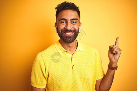 年轻的印度男子用耳机听音乐背景图片