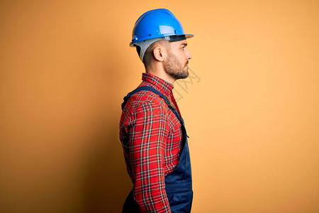 年轻的建筑工人穿着建筑制服和安全头盔图片