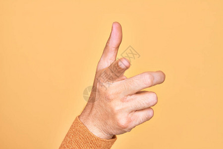 白人年轻人的手在孤立的黄色背景上显示手指背景图片