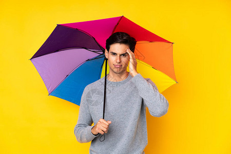 男人拿伞遮挡孤立的黄色背景图片