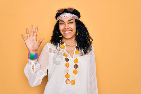 身着太阳镜和古董饰品的年轻非裔美国卷发嬉皮女郎展示并举起五指头图片