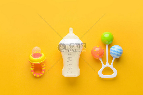 为婴儿和玩具供应奶瓶在彩色背图片