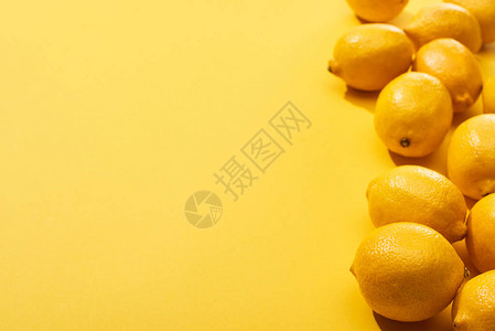 黄色背景上新鲜成熟的整个柠檬背景图片