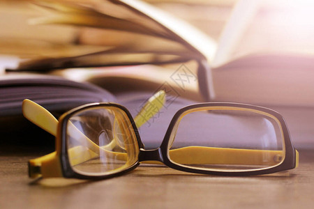 催乳师破碎的黄色眼镜和一本书如此接近背景