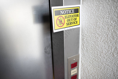 附在电梯门上的黄色电梯停用通知标志图片