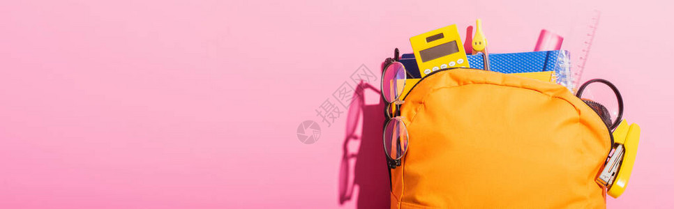 装满学校用品和粉红色眼镜的黄背包黄图片