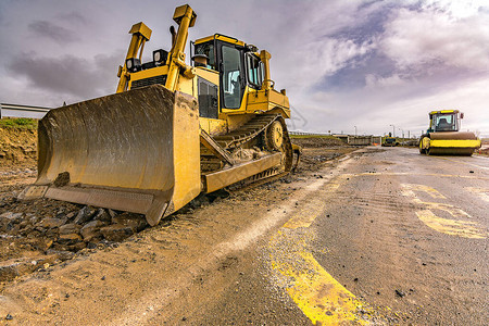 挖掘机在道路建设中平整和平整土地背景图片