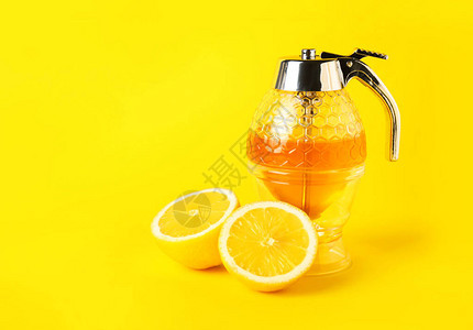 彩色背景中的一罐甜蜂蜜和柠檬图片