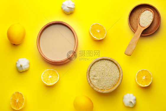 彩色背景中的一碗美味芝麻酱柠檬和大蒜图片