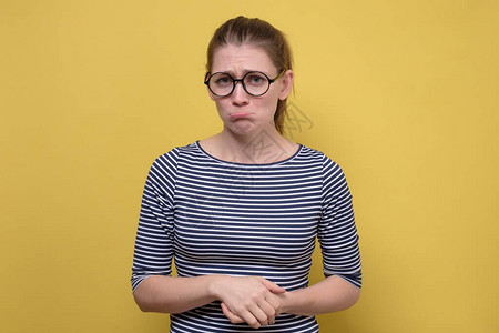戴着眼镜的滑稽困惑的女人感到悲伤和失望人类的表达情感受黄色拍摄的工作图片
