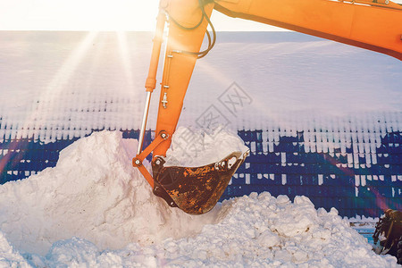带雪的挖掘机铲斗冬季清洁和除雪图片