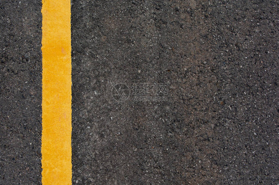 黑色柏油路背景上的黄线带有复制空间图片