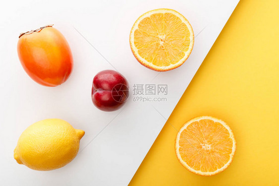 黄色和白色背景的橙色半径persimmon柠檬和苹果图片