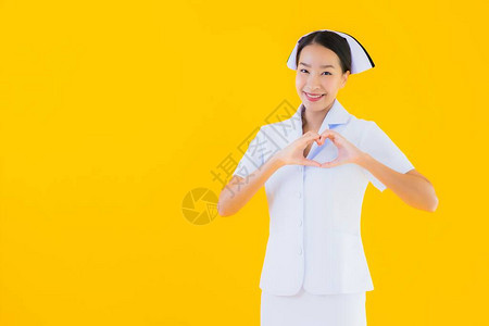 在诊所和医院以黄色孤立背景为病人做许多手术的年轻亚洲泰籍护士图片