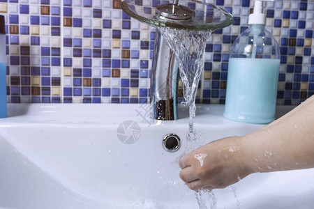 一个小女孩用液肥皂洗手从水龙头迅速倒水图片