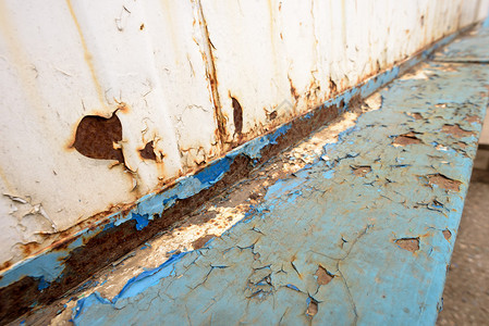 破旧的蓝色金属大梁具有引人注目的独特橙色锈迹和明显的恶化白色油漆和图片