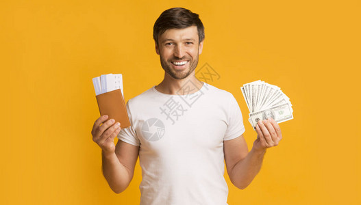 金钱和护照在镜头中微笑站在黄色背景上图片