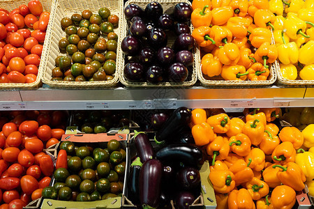 超市柜台配有柳条篮和带新鲜红绿番茄橙黄辣椒图片
