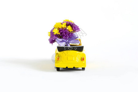 在白色背景上的一辆黄色小车里看到一束五颜六色的紫色花朵选择焦点节日婚礼送花图片