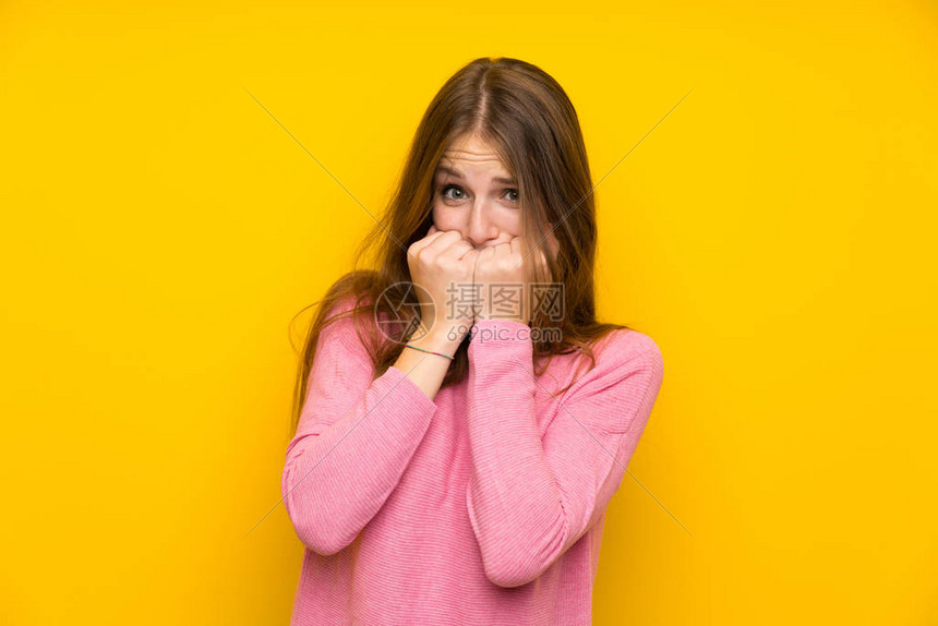 长发的年轻女子在孤立的黄色墙上紧张不安高清图片下载-正版图片504639573-摄图网