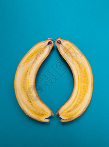 香蕉切开蓝色背景上的两半香蕉成熟的水果背景图片