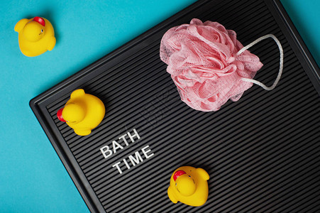 洗澡时间在黑信板上用黄色的橡皮鸭和蓝色背景的淋浴海绵发短信顶部视野平图片