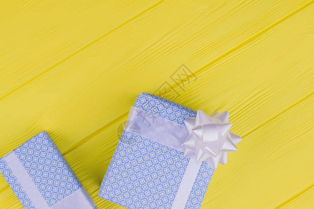 精美包装的礼品盒木制背景上两个礼品盒用蓝色纸包裹在黄色背景上图片