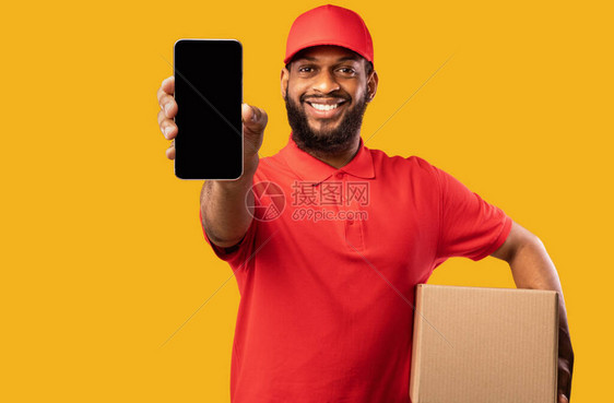 非洲快递小哥在黄色背景上显示带空白屏幕的智能手机图片