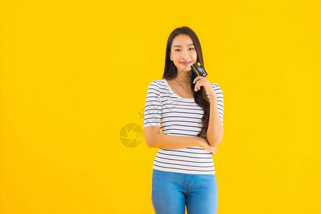 肖像美丽的亚洲年轻女在黄色孤立背景下展示网图片