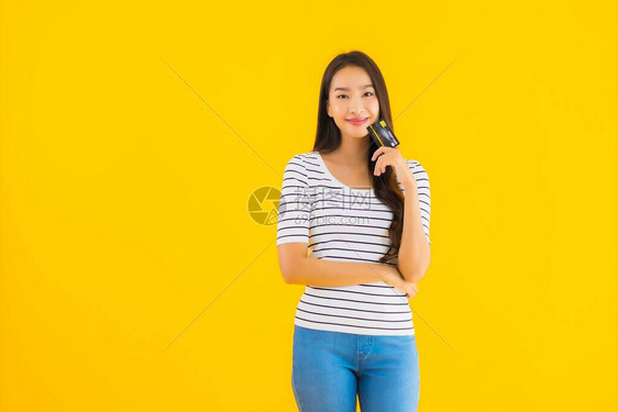 肖像美丽的亚洲年轻女在黄色孤立背景下展示网图片