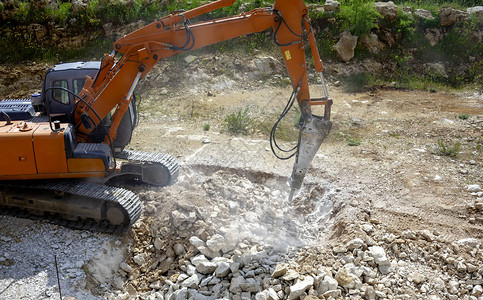 重型建筑业挖掘机在建筑工地碎石的特写图片